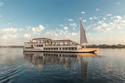 a boat with a sail on the water at HMC Musk Dahabyia in Luxor