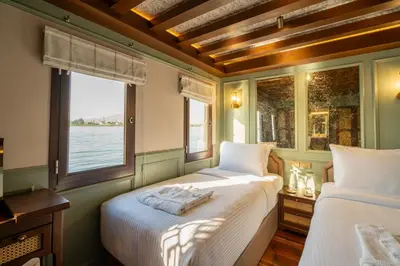 two beds in a room with a window at HMC Musk Dahabyia in Luxor