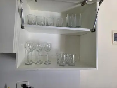 a row of wine glasses on a shelf in a kitchen at Do wynajęcia apartament w Hurghadzie w resorcie Aqua Tropical in Hurghada
