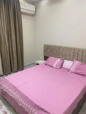 a bedroom with a pink bed with purple sheets and pillows at Al fayrouz resort in Hurghada