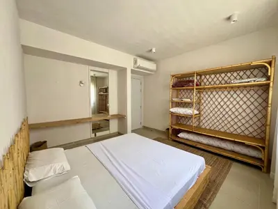 a bedroom with a bed and a shelf with towels at G-Cribs 1BR • Boho Pool Access in Hurghada