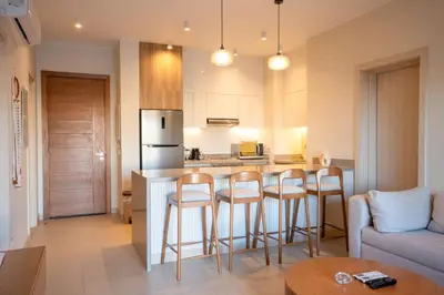 a kitchen and living room with a bar with stools at Shedwan 2BR • Exquisite Ground Floor in Hurghada