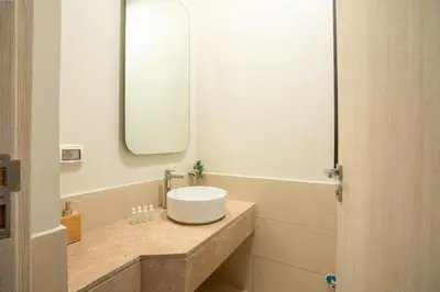 a bathroom with a white sink and a mirror at Shedwan 2BR • Exquisite Ground Floor in Hurghada