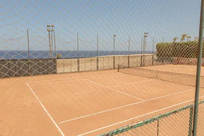 a tennis court with the ocean in the background at Cozy 1 bedroom Apartment in Azzurra Sahl Hasheesh in Hurghada