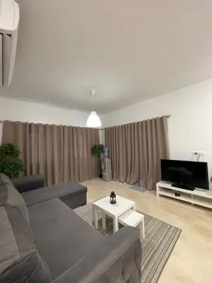 a living room with a couch and a tv at Cozy 1 bedroom Apartment in Azzurra Sahl Hasheesh in Hurghada