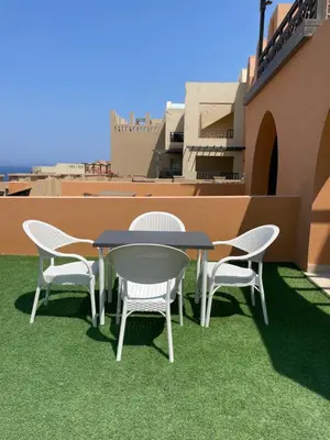 a table and chairs on the roof of a building at Spacious sea view ,1 bedroom apartment in Azzurra Sahl Hasheesh in Hurghada
