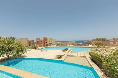 a large swimming pool with buildings in the background at Spacious sea view ,1 bedroom apartment in Azzurra Sahl Hasheesh in Hurghada