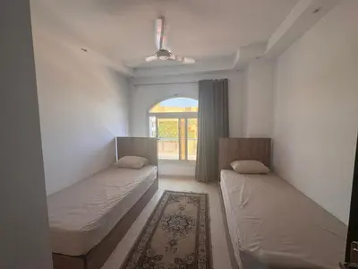 two beds in a room with a window at Florenza Khamasin C105 in Hurghada