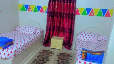 a bedroom with two twin beds and a box at Wateen guest house in Aswan
