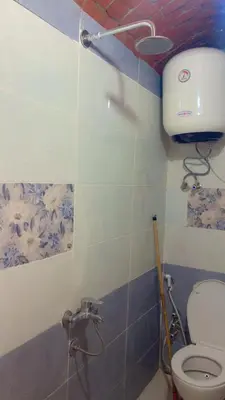 a bathroom with a toilet and a toilet paper dispenser on the wall at Wateen guest house in Aswan