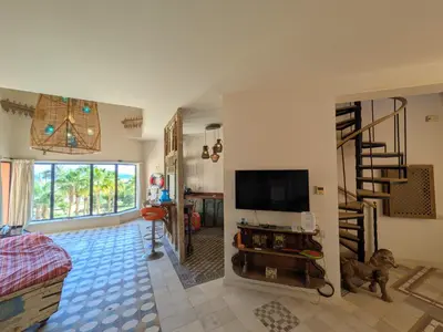 a living room with a television and a staircase at Super Central Somabay 2BR Marina Apt w Free Beach in Hurghada