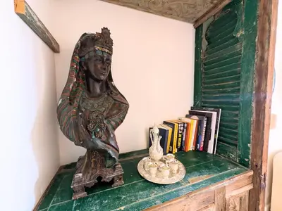 a statue of a woman sitting on a shelf with books at Super Central Somabay 2BR Marina Apt w Free Beach in Hurghada