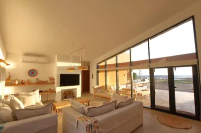 a living room with white furniture and a large window at Seafront 3BR Soma Bay Villa With Exquisite Views in Hurghada