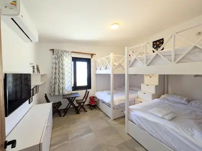 a bedroom with two bunk beds and a desk at Seafront 3BR Soma Bay Villa With Exquisite Views in Hurghada