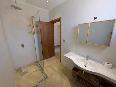 a bathroom with a sink and a mirror and a shower at Seafront 3BR Soma Bay Villa With Exquisite Views in Hurghada