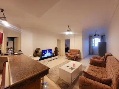 a living room with a couch and a tv at Alisra Hurghada Building in Hurghada