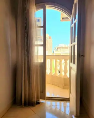 an open door with a view of a balcony at Alisra Hurghada Building in Hurghada
