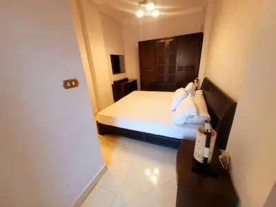 a bedroom with a bed and a door to a room at Alisra Hurghada Building in Hurghada