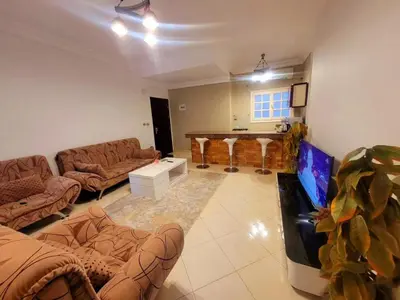 a living room with couches and a flat screen tv at Alisra Hurghada Building in Hurghada