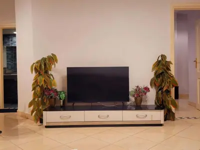 a flat screen tv sitting on top of a entertainment center at Alisra Hurghada Building in Hurghada
