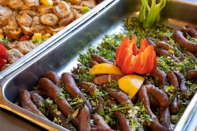 a buffet of food with sausages and other foods at Roma Hotel in Hurghada