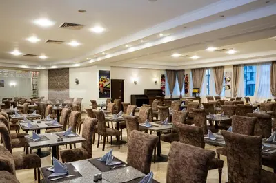 a conference room with tables and chairs and a piano at Roma Hotel in Hurghada