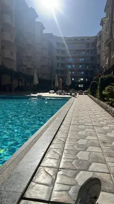 a persons foot standing next to a swimming pool at Princess Resort in Hurghada
