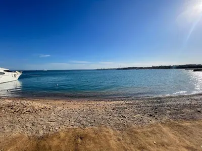 a beach with a boat in the water at Princess Resort in Hurghada