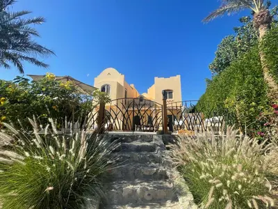 a house in the middle of a garden with palm trees at El Gouna Villa Upper-Nubia, Sleeps 4-6 Persons in Hurghada
