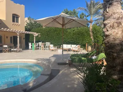 a patio with an umbrella and a swimming pool at El Gouna Villa Upper-Nubia, Sleeps 4-6 Persons in Hurghada