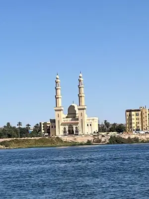 a mosque on the banks of a body of water at Assuan Felucca in Aswan