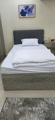 a bedroom with a bed with white sheets and a rug at Crystal chalet in Hurghada