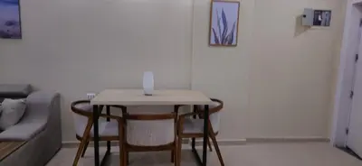 a table with chairs and a candle on it in a living room at Crystal chalet in Hurghada