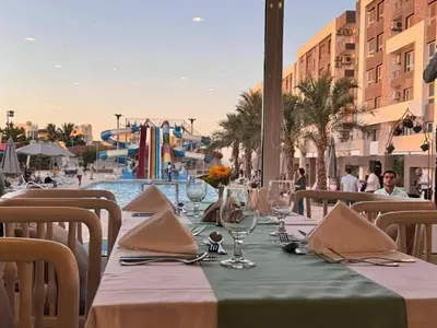 a table with glasses and napkins on a table near a pool at Crystal chalet in Hurghada