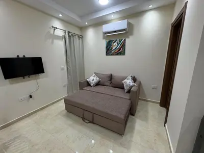 a living room with a couch and a flat screen tv at La Quinta Hurghada Pool & Sea View Ground floor in Hurghada