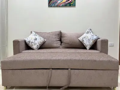a brown couch with two pillows on top of it at La Quinta Hurghada Pool & Sea View Ground floor in Hurghada
