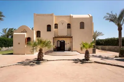 a building with palm trees in front of it at Stylish Villas in North Golf El Gouna in Hurghada