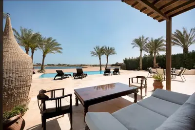 a patio with a couch and chairs and a pool at Stylish Villas in North Golf El Gouna in Hurghada