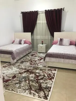 a bedroom with two beds and a rug at Sun Garden Villa in Luxor
