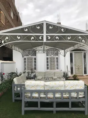 a patio with a couch under an umbrella at Sun Garden Villa in Luxor