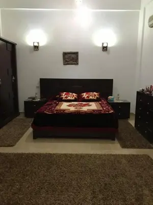 a bedroom with a bed and two dressers at Sun Garden Villa in Luxor