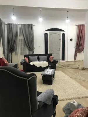 a living room with a black couch and a table at Sun Garden Villa in Luxor