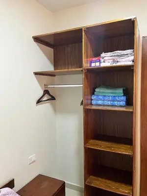 a wooden book shelf with folded towels in a room at Studio Pool & Sea View Princess Resort in Hurghada