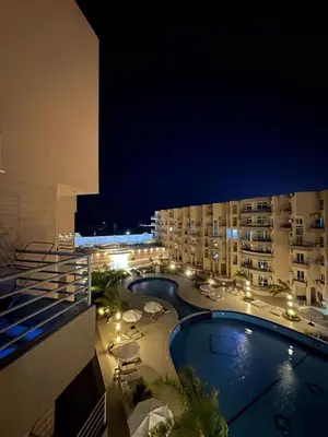a view of a hotel at night with a swimming pool at Studio Pool & Sea View Princess Resort in Hurghada