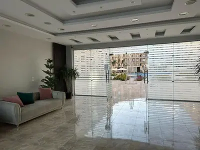 a living room with a couch and a large window at Studio Pool & Sea View Princess Resort in Hurghada
