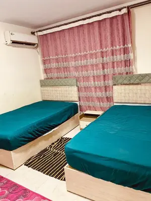 two beds in a room with a window at Nesim hights compound in Hurghada