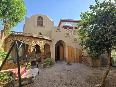 a house with a swing in front of it at Villa Harmony Luxor in Luxor