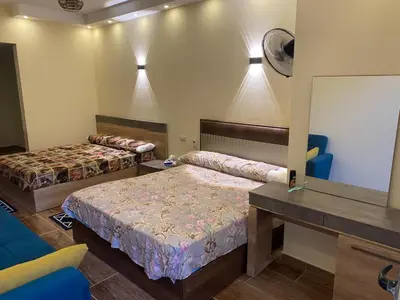 a bedroom with two beds and a mirror at Florenza compound in Hurghada