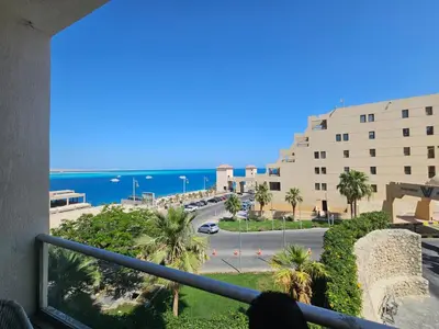 a view of the ocean from a balcony of a building at Old Sheraton street apartment in Hurghada