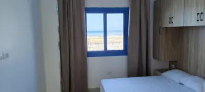 a bedroom with a window with a view of the beach at isis MARINA in Hurghada